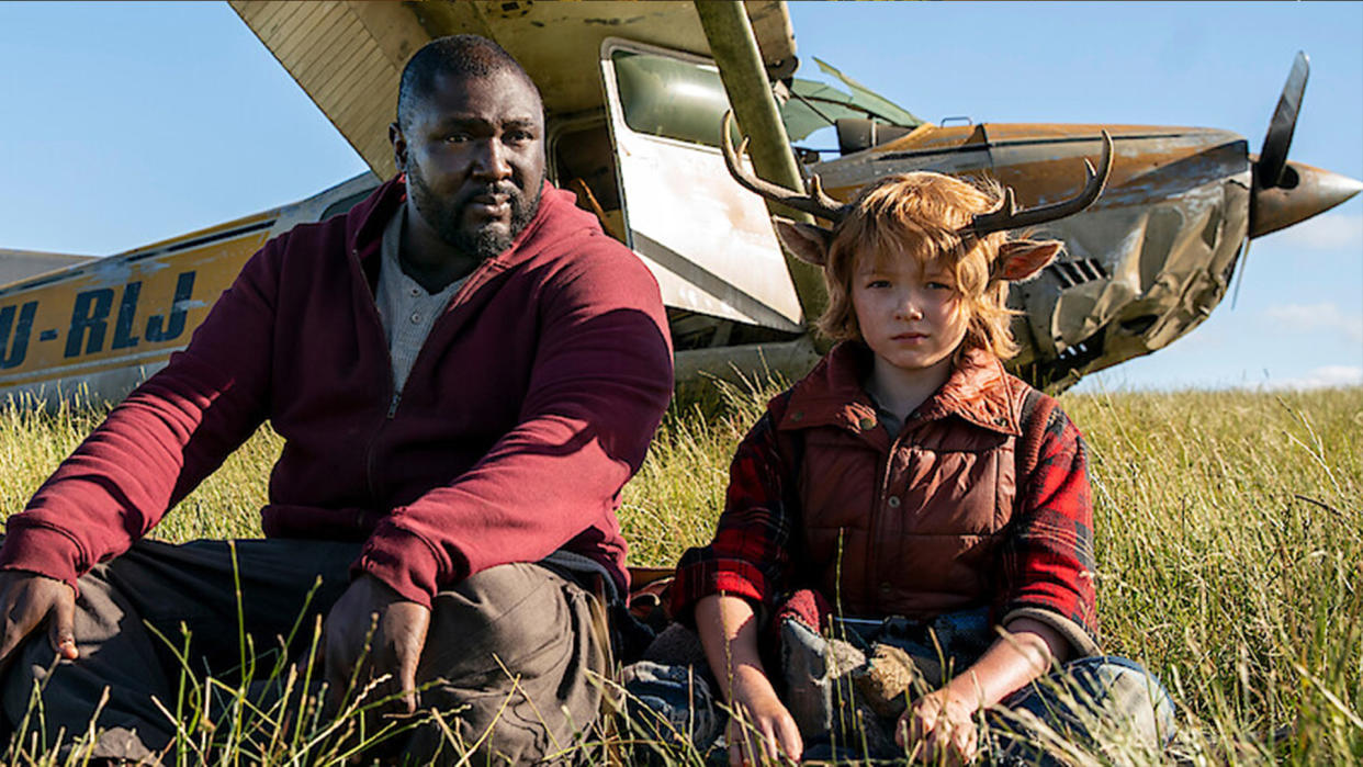  A still from Netflix's Sweet Tooth series of two people sat in front of a plane. 