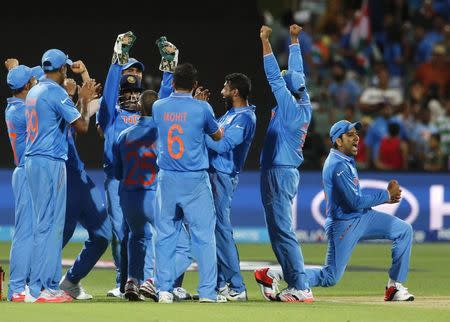 Members of India's cricket team celebrate after an electronic review confirmed the dismissal of Pakistan's batsman Umar Akmal, caught by wicket keeper Mahendra Dhoni (C, helmet), during their Cricket World Cup match in Adelaide, February 15, 2015. REUTERS/David Gray