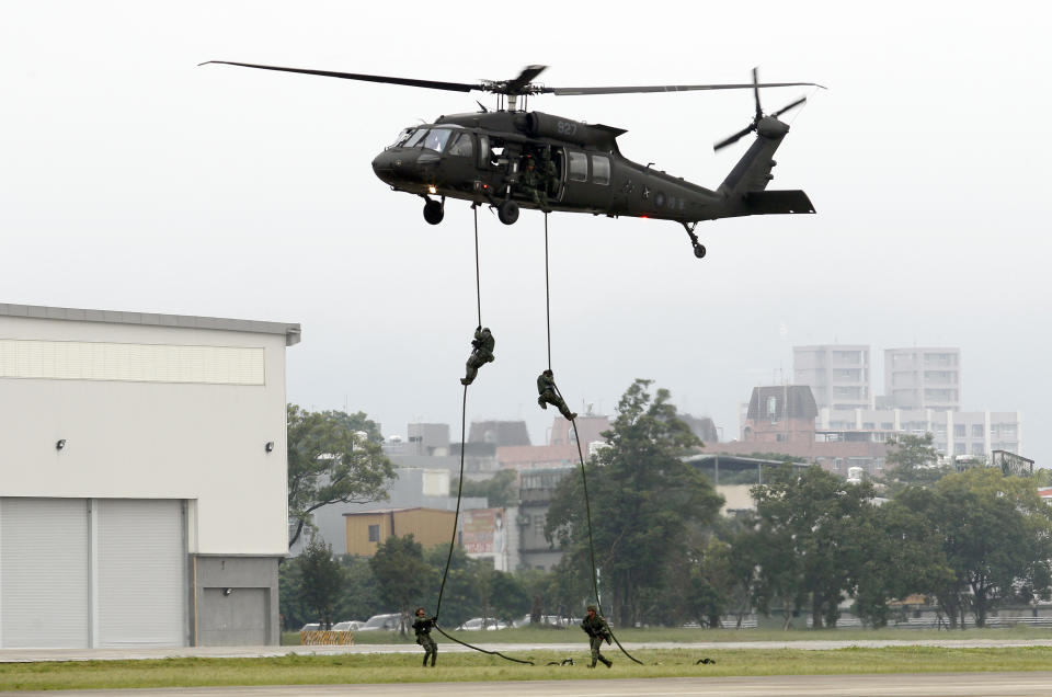 Taiwan's special forces members rappel from a UH-60M Black Hawk helicopter during a military drill in Taoyuan city, Nothern Taiwan, Tuesday, Oct. 9, 2018. Taiwanese President Tsai Ing-wen hosted her Paraguayan counterpart Tuesday at a military exercise in a sign of the island's determination to withstand China's diplomatic onslaught. The joint land and air training exercise simulated an attempt by Chinese forces to attack a Taiwanese air base in the north of the island.(AP Photo/Chiang Ying-ying)