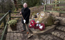 Tony Foulds holds a broom as he stands next to a memorial honouring 10 U.S. airmen who died in a plane crash in Endcliffe Park, Sheffield, England, Wednesday, Feb. 13, 2019. Foulds was just a kid running around in the park when a U.S. Air Force crew decided to crash and die rather than take the chance of hitting them on Feb. 22, 1944. He's dreamed of honoring them for decades. Now he's 82 and about to get his wish. (AP Photo/Rui Vieira)