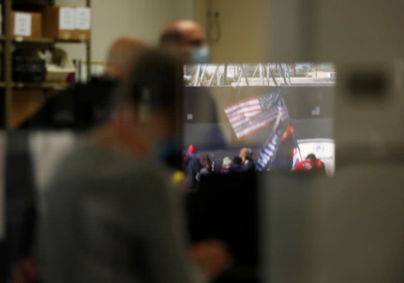 FILE PHOTO: Protesting supporters of U.S. President Donald Trump are reflected in a window at the Maricopa County Tabulation and Election Center