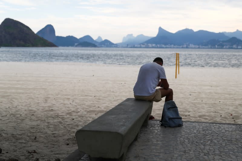 A man sits on a bench at the Icarai beach, banned for users during the coronavirus disease (COVID-19) outbreak, in Niteroi
