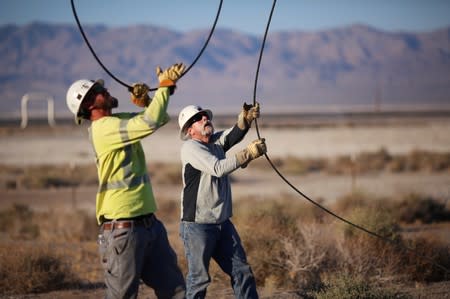 Linemen repair lines that were broken during a powerful earthquake that struck Southern California, near the epicenter, northeast the city of Ridgecrest