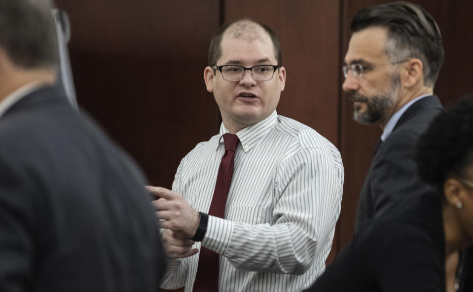 FILE - Timothy Jones Jr., center, charged with killing his five children, speaks with his attorneys, Boyd Young, left, and Casey Secor during his trial in Lexington, S.C., Wednesday, May 22, 2019. South Carolina Supreme Court justices are questioning whether a prosecutor offered to show photos of five dead children to a jury to unfairly upset them so they would sentence their father to death. The high court heard 39-year-old Timothy Jones' request to overturn his murder convictions and death sentence on Tuesday, Nov. 9, 2021. (Tracy Glantz/The State via AP, Pool, File)