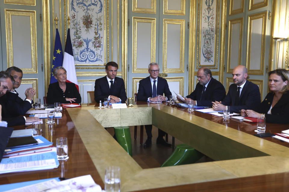 French President Emmanuel Macron, center, chairs a government emergency meeting at the emergency crisis center of the Interior Ministry in Paris, Sunday, July 2, 2023 after a 17-year-old whose killing by police has triggered days of rioting and looting across the nation. (Mohamed Badra, Pool via AP)