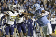 North Carolina tight end Bryson Nesbit (18) fends off Georgia Tech defensive back Kenny Bennett (25) and linebacker Ayinde Eley (2) as he runs for a big gain after a pass reception during the first half of an NCAA college football game, Saturday, Nov. 19, 2022, in Chapel Hill, N.C. (AP Photo/Chris Seward)