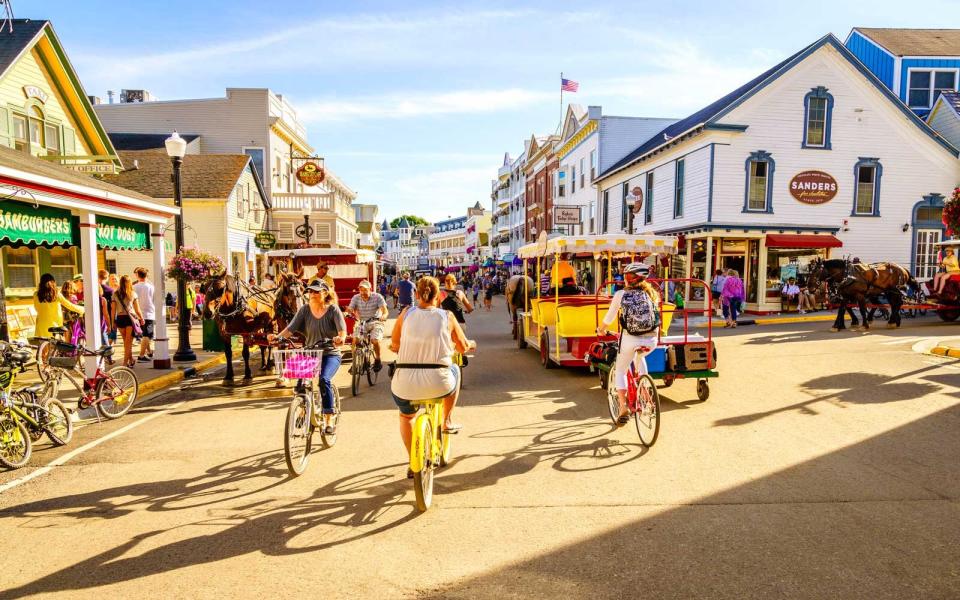 Vacationers take on Market Street on Mackinac Island that is lined with shops and restaurants.