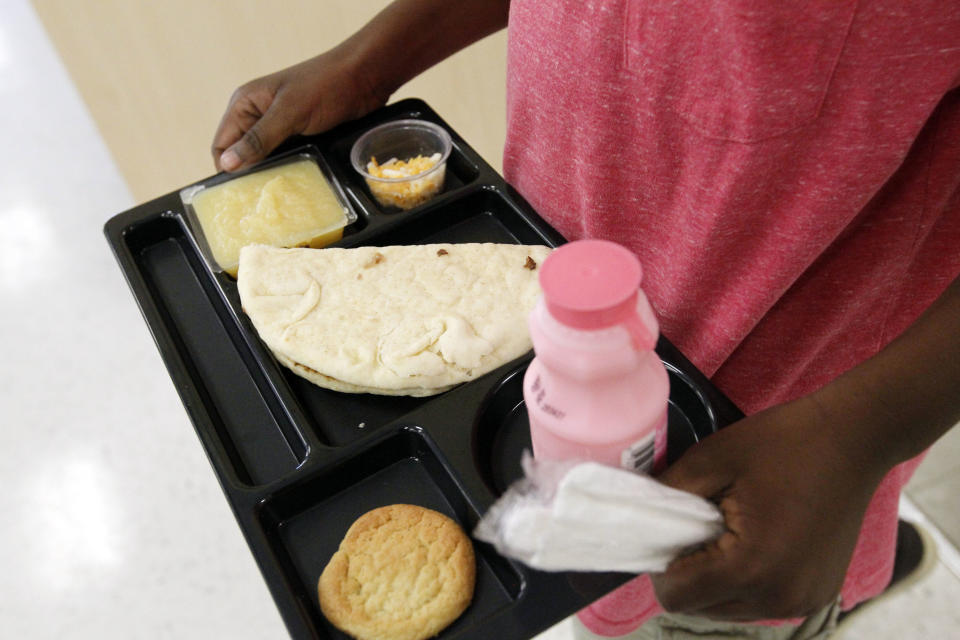 A student at Eastside Elementary School in Clinton, Miss., carries out a noon meal consisting of a flat bread roast beef sandwich, apple sauce, strawberry milk and a cookie, Wednesday, Sept. 12, 2012. The leaner, greener school lunches served under new federal standards are getting mixed grades from students. (AP Photo/Rogelio V. Solis)