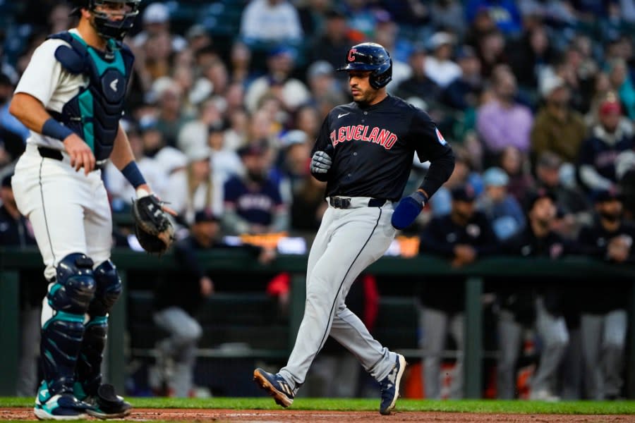 Cleveland Guardians’ Ramón Laureano scores as Steven Kwan grounds into a force out while Seattle Mariners catcher Cal Raleigh stands near home plate during the third inning of a baseball game Monday, April 1, 2024, in Seattle. (AP Photo/Lindsey Wasson)