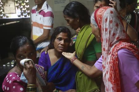 Relatives mourn for a victim who died after consuming bootleg liquor at a cremation ground in Mumbai, June 20, 2015. REUTERS/Danish Siddiqui