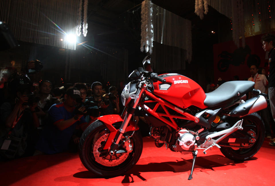 FILE - In this Oct. 20, 2011 file photo photographers take photos of Ducati's new model "Monster 795" during its unveiling in Kuala Lumpur, Malaysia. Volkswagen AG's Audi unit says it will buy Italian motorcycle maker Ducati Motor Holding SpA from Investindustrial Group. Audi did not disclose the purchase price in announcing the deal. It said the acquisition was approved Wednesday, April 18, 2012 by the supervisory boards of both Audi and parent Volkswagen. (AP Photo/Lai Seng Sin, File)