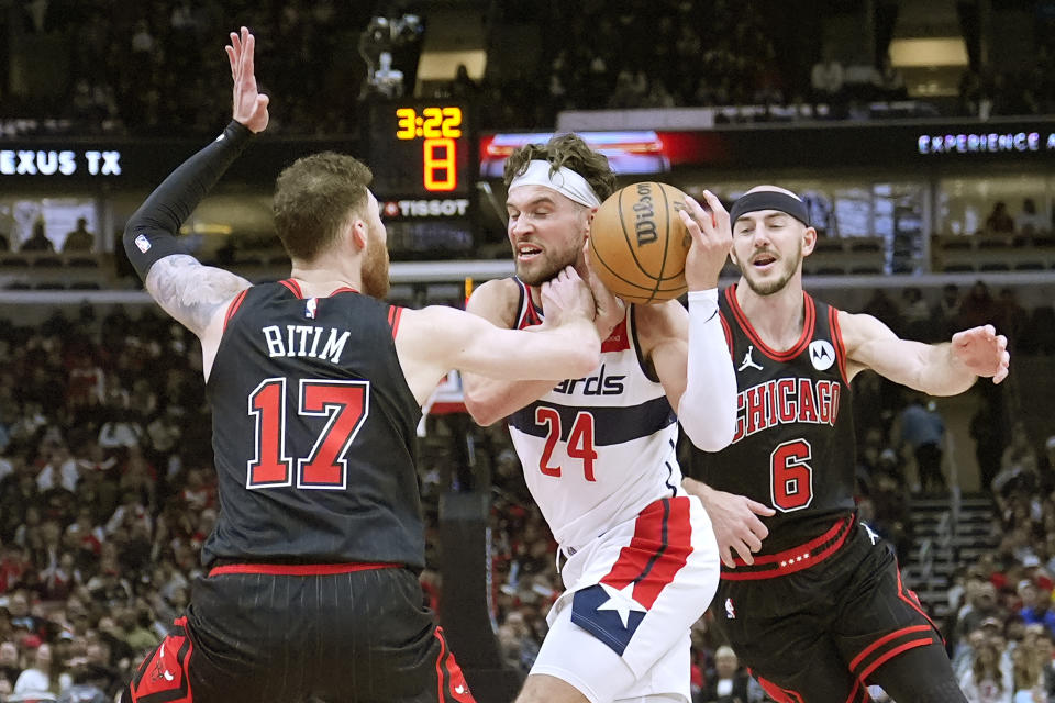 Washington Wizards' Corey Kispert (24) is fouled by Chicago Bulls' Onuralp Bitim (17) as Alex Caruso also defends during the first half of an NBA basketball game Monday, March 25, 2024, in Chicago. (AP Photo/Charles Rex Arbogast)