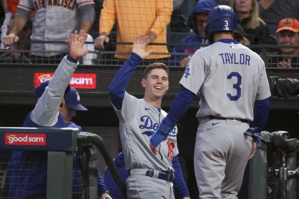 Dodgers' Chris Taylor, right, celebrates with Will Smith while entering the dugout after scoring