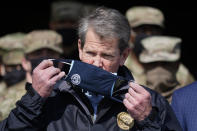 FILE - In this Feb. 19, 2021, file photo, Georgia Gov. Brian Kemp removes his face covering as he prepares to speak to reporters at the Macon State Farmers Market in Atlanta. The COVID-19 relief package passed by Congress contains a windfall for state governments. But some Republican governors are complaining about the formula used to dole out the money. “Instead of using the bipartisan blueprint of previous federal coronavirus relief bills, this legislation is literally a wish list for California and New York,” Kemp said. “And quite honestly, it’s a slap in the face for my fellow Georgians.” (AP Photo/John Bazemore, File)