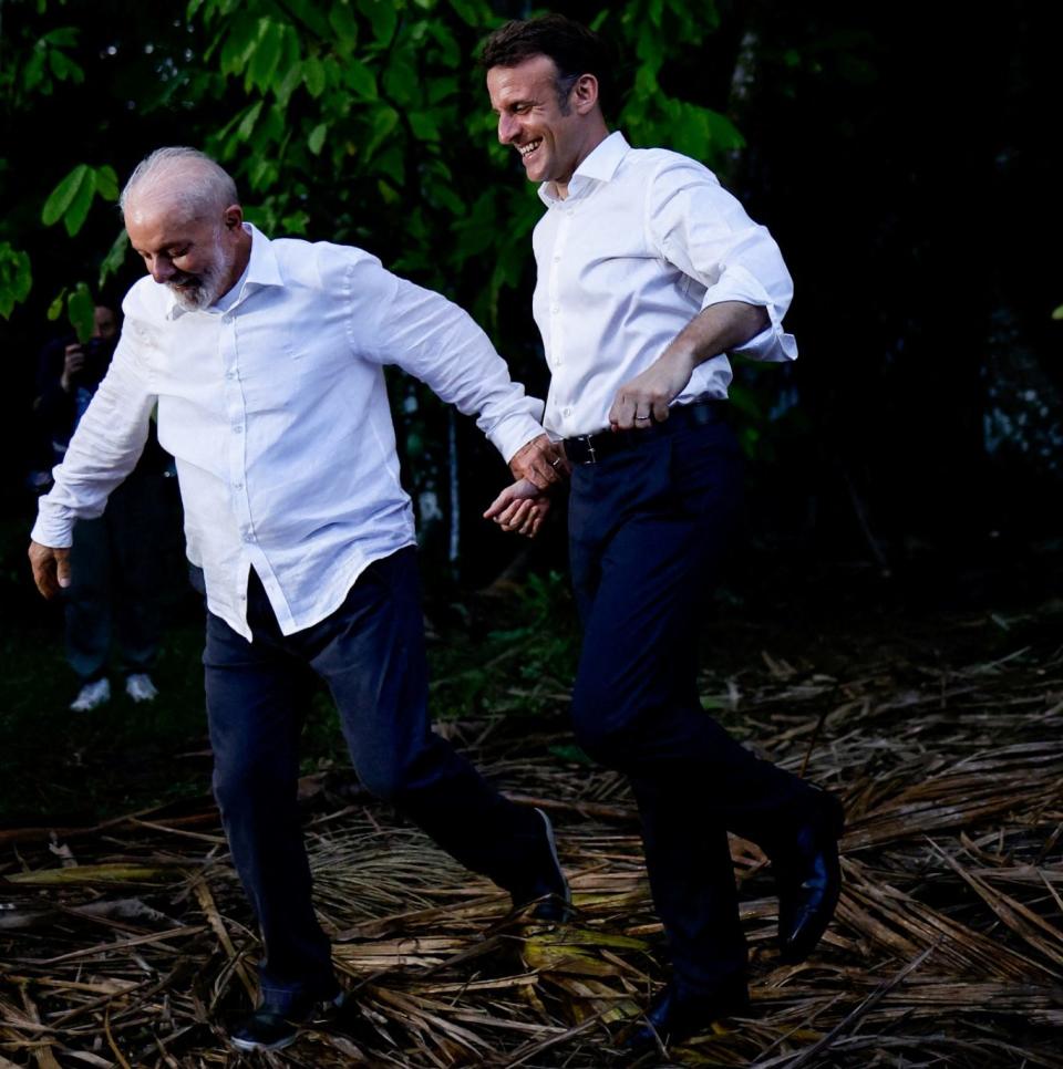 Luiz Inacio Lula da Silva leads Emmanuel Macron through the jungle