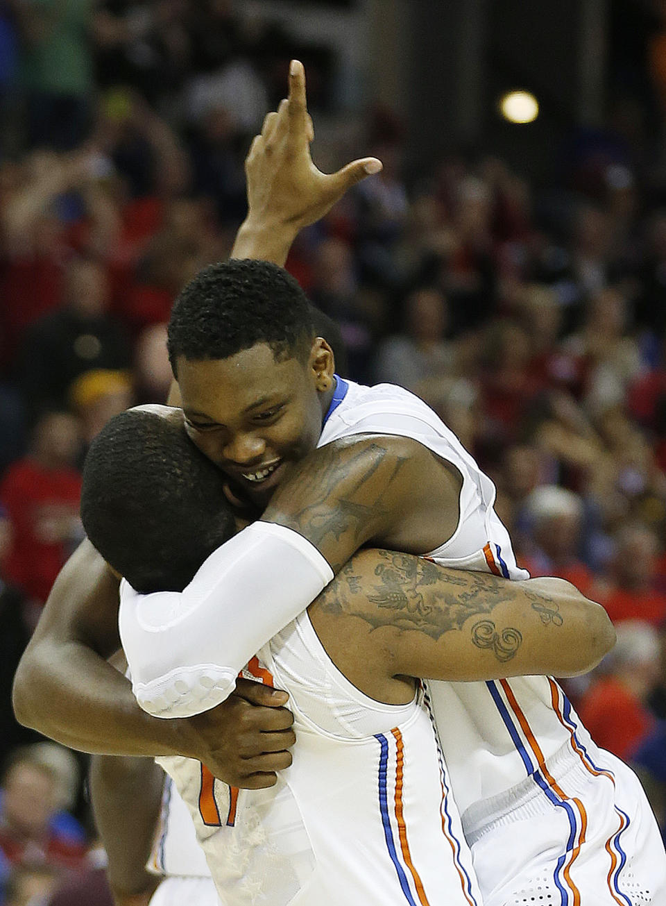 Florida's Lexx Edwards (11) holds Michael Frazier II (20) after the second half in a regional final game against Dayton at the NCAA college basketball tournament, Saturday, March 29, 2014, in Memphis, Tenn. Florida won 62-52. (AP Photo/John Bazemore)