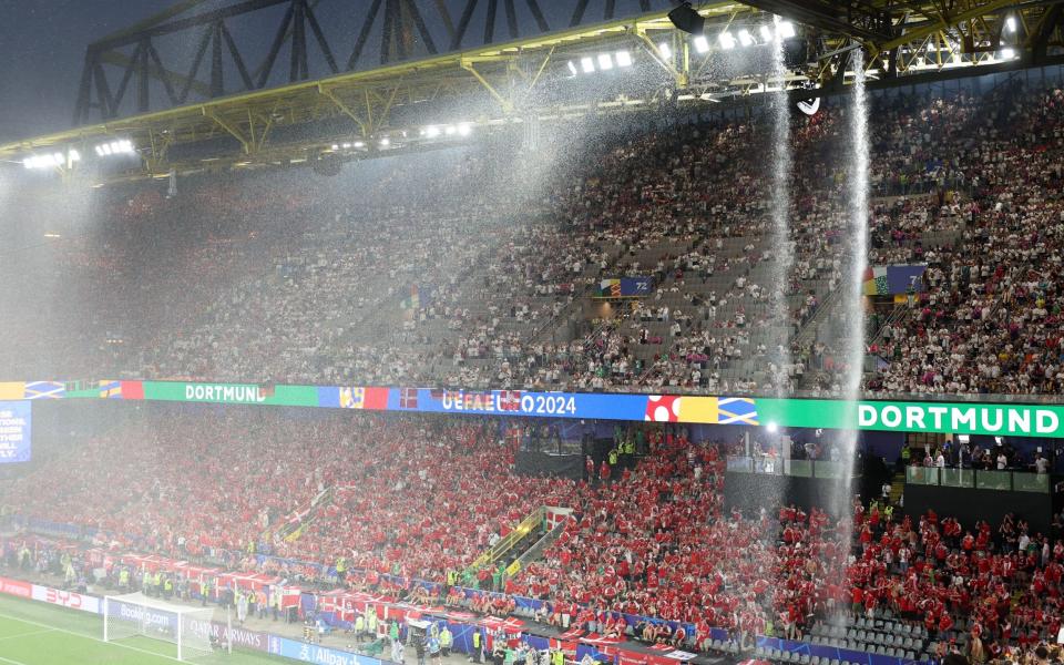 Supporters brave the elements as match is interrupted due to thunder and lightning during the UEFA EURO 2024 Round of 16 soccer match between Germany and Denmark