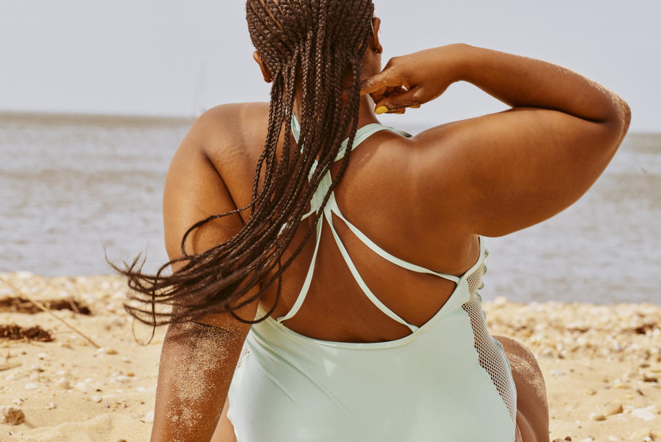 a woman sitting in the sand on a beach