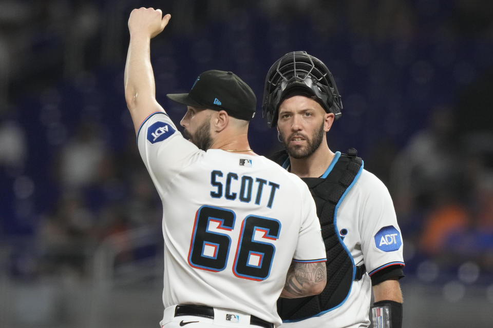 Miami Marlins relief pitcher Tanner Scott (66) talks on the mound with catcher Jacob Stallings, right, during the ninth inning of a baseball game against the New York Mets, Monday, Sept. 18, 2023, in Miami. (AP Photo/Lynne Sladky)