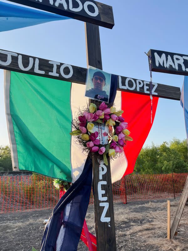 Una cruz de madera en memoria del difunto migrante Julio López se muestra en un memorial para migrantes que murieron asfixiados mientras eran contrabandeados en un tráiler, en San Antonio.