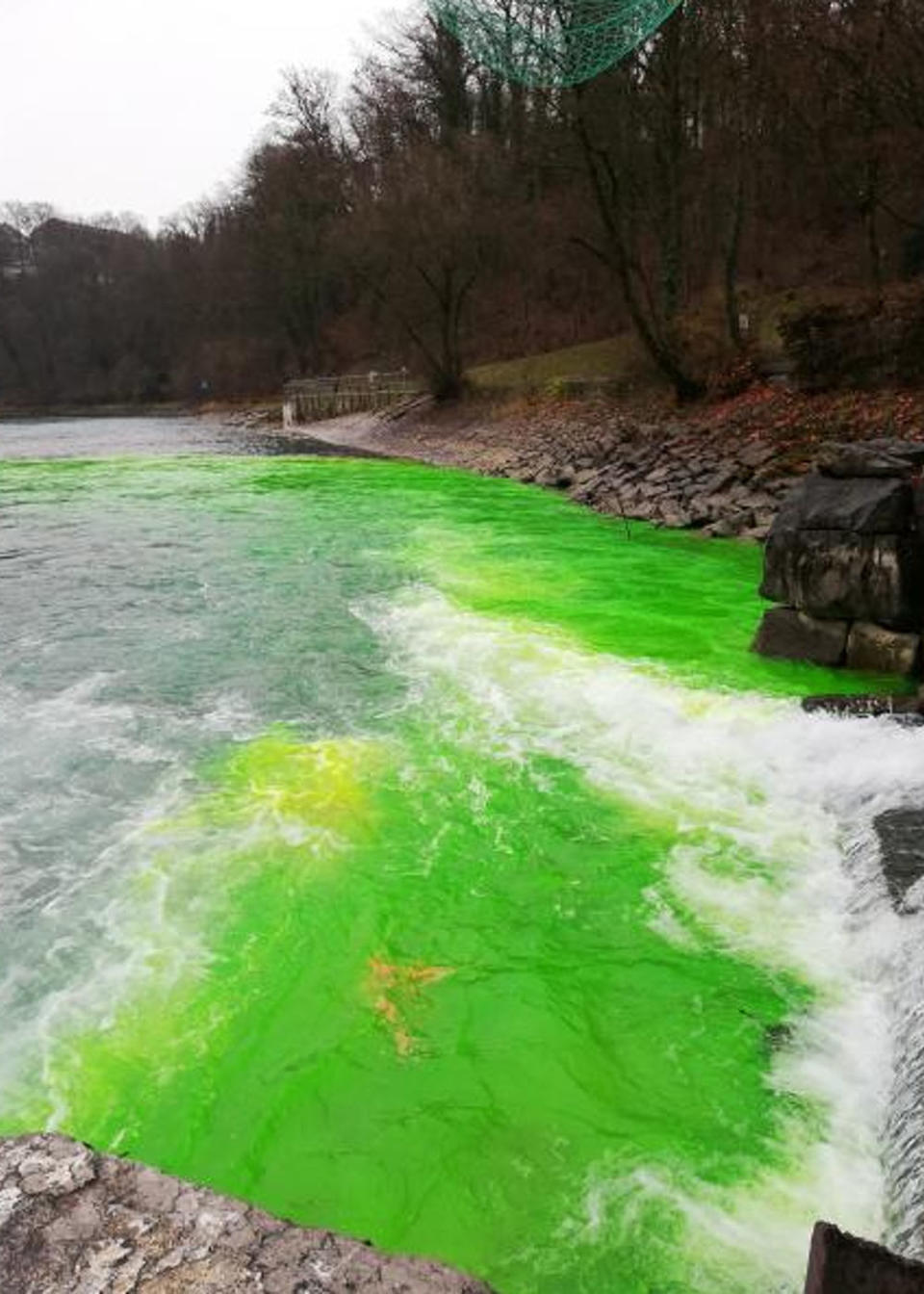 Political activists dyed a Swiss river bright green to highlight the dangers of a nearby ammunitions depot that is being disassembled. Source: CEN/Australscope