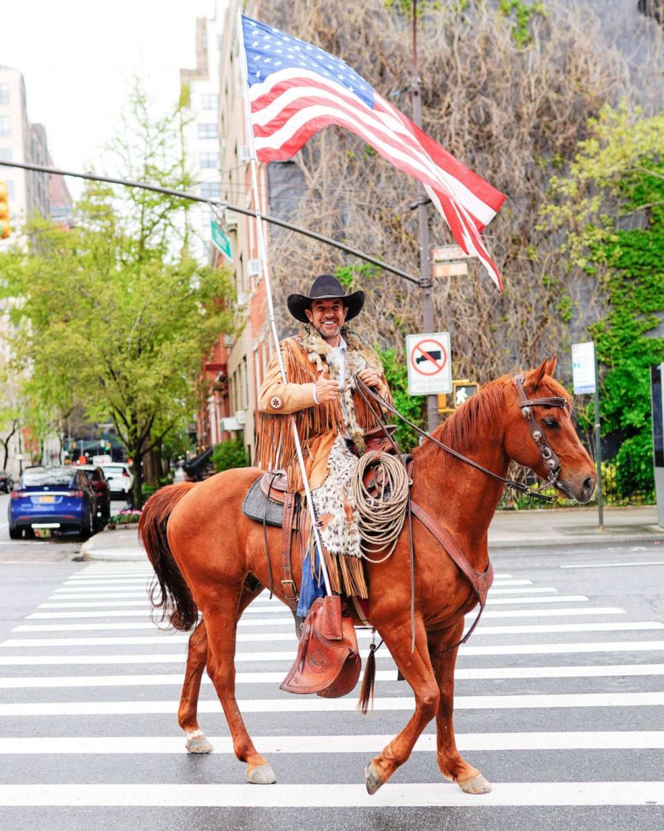 PHOTO: In this May 1, 2020, file photo, Cowboys for Trump founder Couy Griffin waves an American flag while riding a horse up Sixth Avenue during the COVID-19 pandemic in New York. (Gotham/Getty Images, FILE)