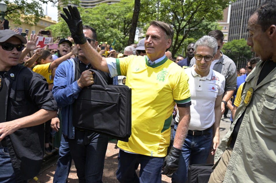 A member of a security detail holds a black bag with bulletproof plates as protection for Brazil's President Jair Bolsonaro as he greets supporters during a campaign rally in Praca da Liberdade or Liberty Square, in Belo Horizonte, Brazil, Saturday, Oct. 29, 2022. Bolsonaro is facing former President Luiz Inacio Lula da Silva in a runoff election set for Oct. 30. (AP Photo/Yuri Laurindo)