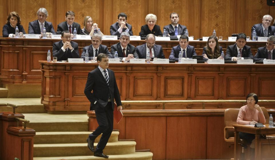 Romanian Parliament speaker Crin Antonescu walks after resigning his post in Bucharest, Romania, Tuesday, March 4, 2014. Antonescu, the leader of the Liberal party, stepped down as Senate speaker, after his junior party left the ruling coalition over disagreements with the prime minister, Victor Ponta, at left center row, who turned down its nomination for interior minister. (AP Photo/Andreea Alexandru/Mediafax) ROMANIA OUT
