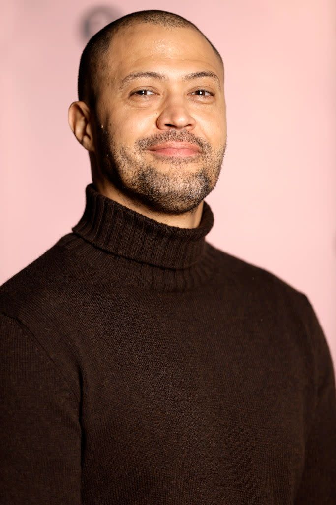 cord jefferson smiles at the camera while looking slightly to the left, he wears a black turtleneck sweater