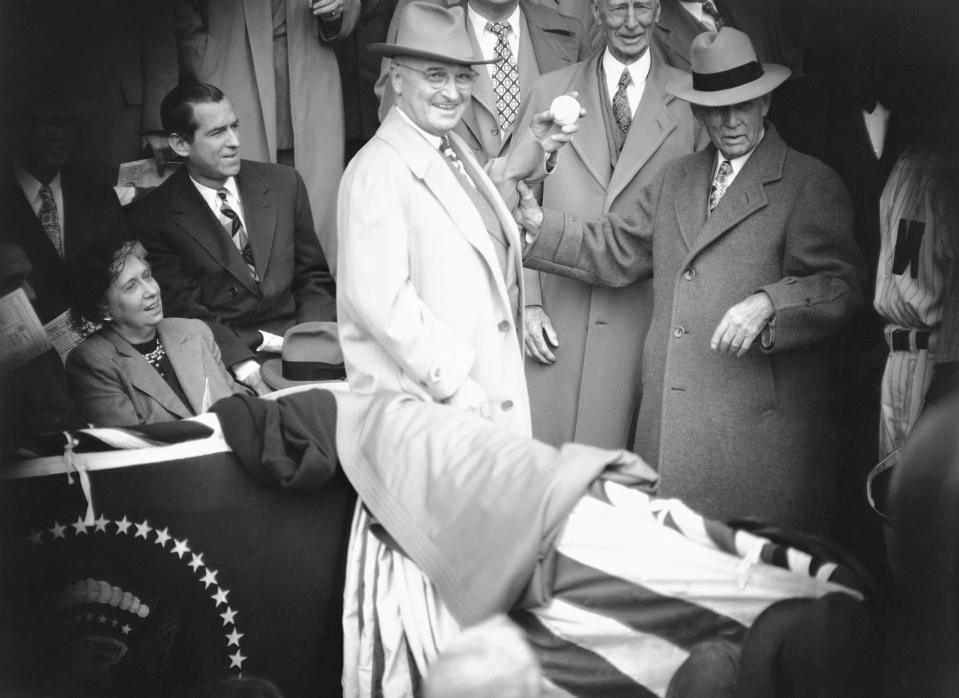 FILE - In this April 18, 1949, file photo, Clark Griffith, right, president of the Washington Senators, watches President Harry Truman, throws out the first pitch in Washington. Griffith holds Truman's arm just before the throw as Connie Mack, manager of the Philadelphia Athletics, watches. (AP Photo/William J. Smith, File)