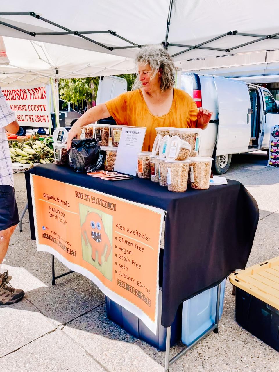 Debbie Meritsky, co-founder of Eat My Granola hands a customer a container of her Krak granola at Market Square, Knoxville on Aug. 31, 2022.