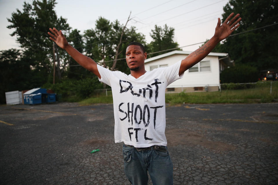 FERGUSON, MO - AUGUST 11:  Protesters are forced by police from the business district into nearby neighborhoods on August 11, 2014 in Ferguson, Missouri. Police responded with tear gas and rubber bullets as residents and their supporters protested the shooting by police of an unarmed black teenager named Michael Brown who was killed Saturday in this suburban St. Louis community. Yesterday 32 arrests were made after protests turned into rioting and looting in Ferguson.  (Photo by Scott Olson/Getty Images)