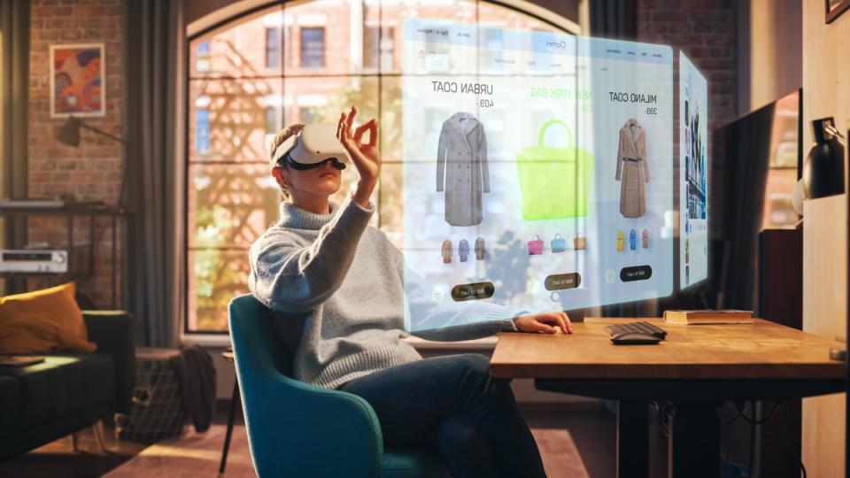 A person in their living room wearing a virtual reality headset and browsing an online apparel store with augmented reality.