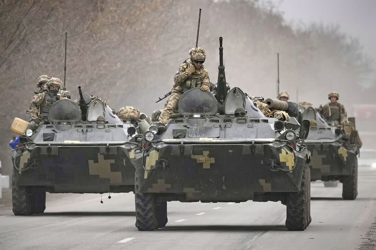 FILE - Ukrainian servicemen sit atop armored personnel carriers driving on a road in the Donetsk region, eastern Ukraine, Thursday, Feb. 24, 2022. (AP Photo/Vadim Ghirda, File)