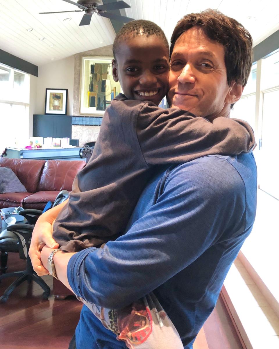 Free Press columnist Mitch Albom with Knox, 8, an orphan from the Have Faith Haiti mission.