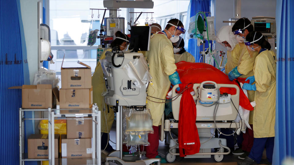 Firefighters Dan Joslin (C) and Matt Smither (2R) help prone a Covid-19 patient as they work alongside critical care nurses in the Intensive Care Unit (ICU) at Queen Alexandra Hospital in Portsmouth, southern England on March 23, 2021. (Adrian Dennis/AFP via Getty Images)