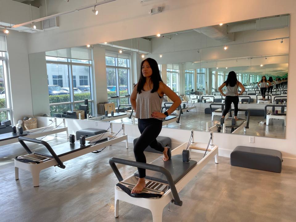 The writer stands on a Pilates machine and does a lunge