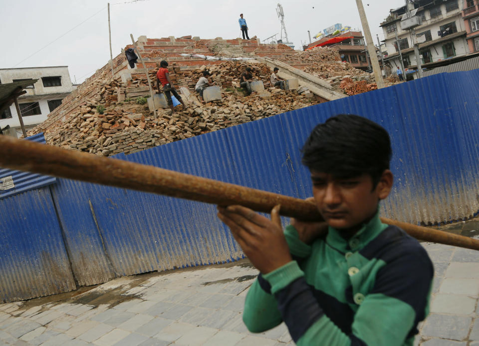 A Nepalese reconstruction laborer works on a reconstruction site in Basantapur Durbar square on the anniversary of the 2015 earthquake, in Kathmandu, Nepal, Thursday, April 25, 2019. The violence of the 7.8-magnitude earthquake killed nearly 9,000 people and left countless towns and villages across central Nepal in shambles. (AP Photo/Niranjan Shrestha)