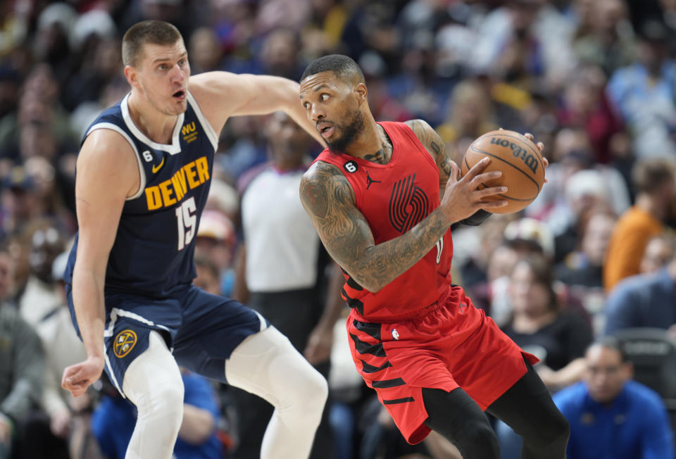 Portland Trail Blazers guard Damian Lillard, right, is defended by Denver Nuggets center Nikola Jokic during the second half of an NBA basketball game Tuesday, Jan. 17, 2023, in Denver. (AP Photo/David Zalubowski)