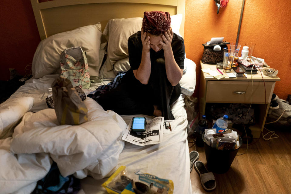 KISSIMMEE, FLORIDA - June 27: Living in an extended stay budget hotel because they cannot afford or find affordable housing, Aja Mallow, center, stressfully and strategically pays bills with the little money they have, with boyfriend, Robert Booher, left, and son, Brian Mallow, 9, at the Duo Boutique Hotel along US Route 192 in Kissimmee, Florida  Thursday June 27, 2019. (Photo by Melina Mara/The Washington Post via Getty Images)