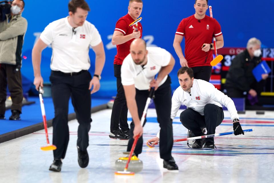 Norway's Steffen Walstaf (right) looks on as Magnus Vaagberg (left) and Markus Hoeiberg sweep the ice (PA)