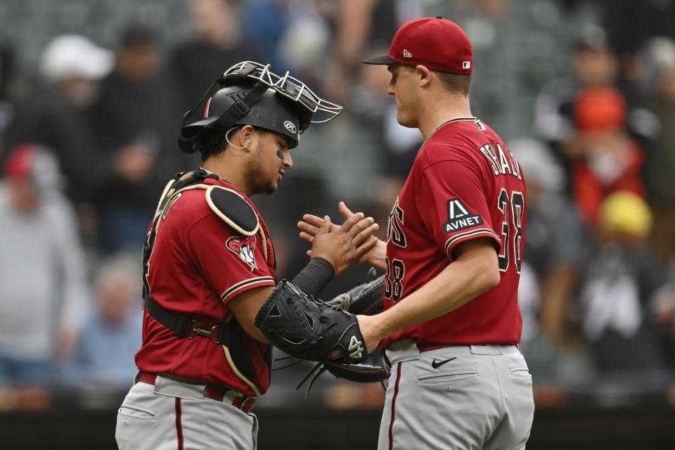 Gabriel Moreno (14) and Paul Sewald (38) of the Arizona Diamondbacks celebrate the 3-0 win against the Chicago White Sox at Guaranteed Rate Field on Sept. 27, 2023, in Chicago, Illinois.