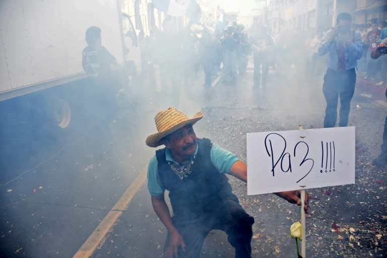 A man holds a sign reading "Peace" after Congress voted unanimously to strip embattled President Otto Perez's immunity in Guatemala City, on September 1, 2015
