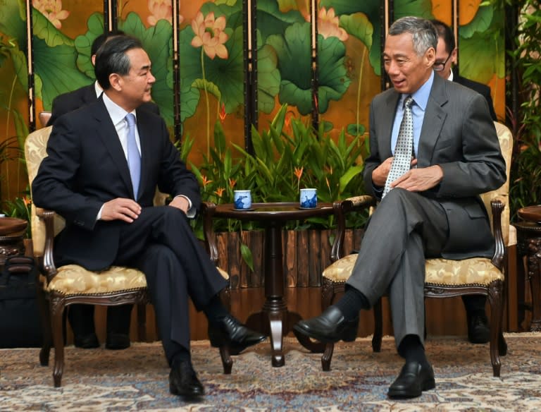 Chinese Foreign Minister Wang Yi (L) talks with Singaporean Prime Minister Lee Hsien Loong at the Istana presidential palace in Singapore on August 3, 2015