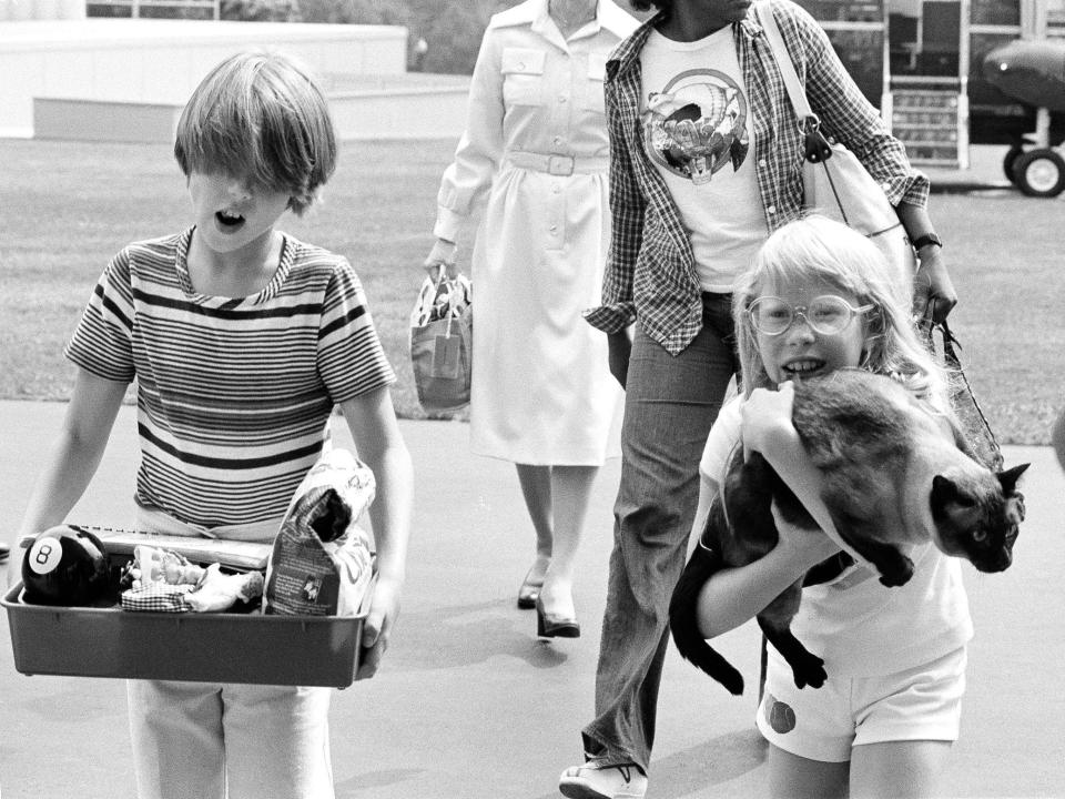 President Carter's daughter Amy Carter holds her cat Misty as she returns from Camp David