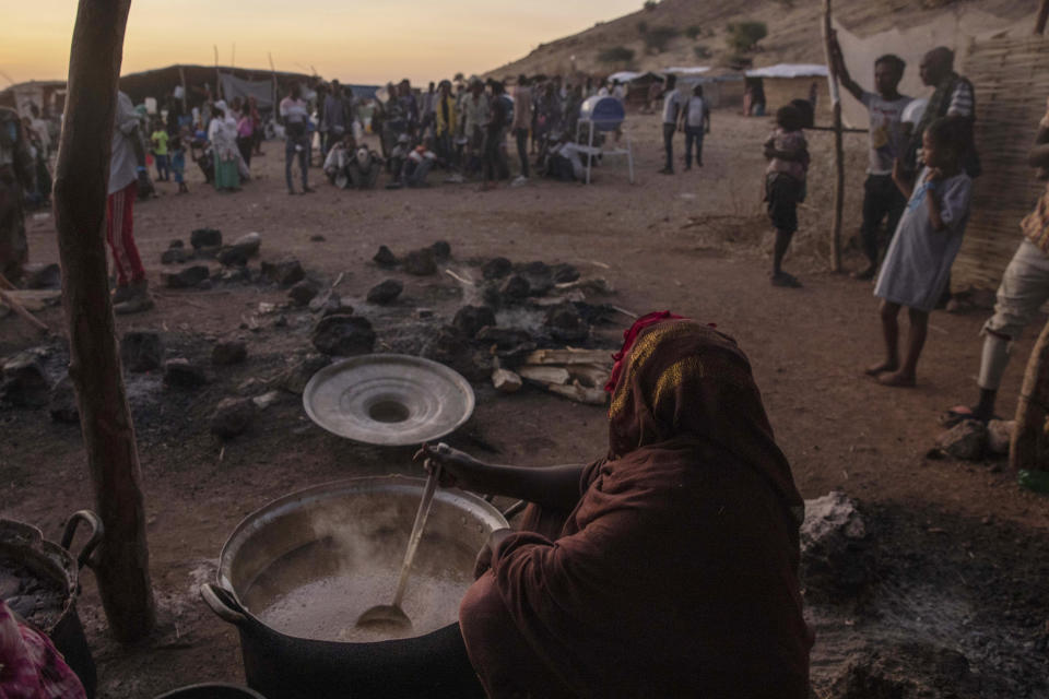 Sudanese women volunteer to cook for Tigray people who fled the conflict in Ethiopia's Tigray region, at Umm Rakouba refugee camp in Qadarif, eastern Sudan, Thursday, Nov. 26, 2020. Ethiopia's prime minister said Thursday the army has been ordered to move on the embattled Tigray regional capital after his 72-hour ultimatum ended for Tigray leaders to surrender, and he warned the city's half-million residents to stay indoors and disarm. (AP Photo/Nariman El-Mofty)