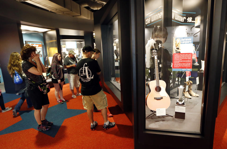 In this April 10, 2014, photo, visitors looks at an exhibit in a new section of the Country Music Hall of Fame and Museum in Nashville, Tenn. A $100 million expansion has added more than 200,000 square feet of space to the existing building. (AP Photo/Mark Humphrey)