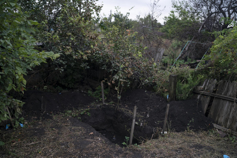 The site where the bodies of two men who had been buried by the side of a road is seen in the freed village of Hrakove, Ukraine, Tuesday, Sept. 13, 2022. (AP Photo/Leo Correa)