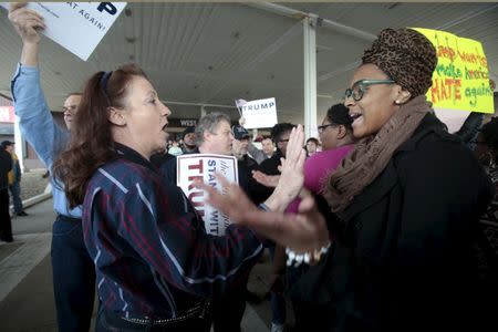 A Trump supporter (L) and a anti-Trump protester voice their opinions to each other following a campaign rally for Republican U.S. presidential candidate Donald Trump in Cleveland, Ohio, March 12, 2016. REUTERS/Rebecca Cook