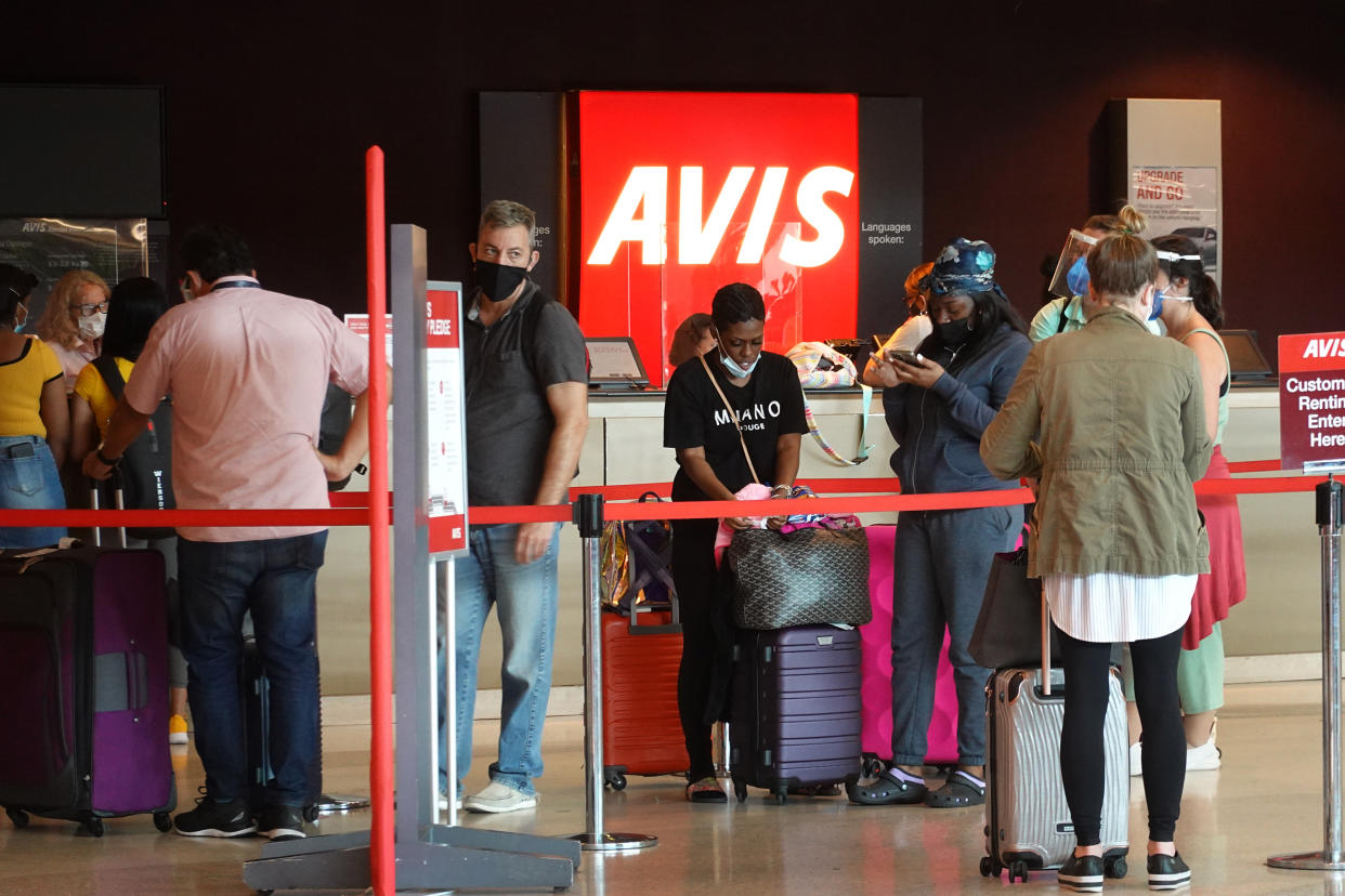 MIAMI, FLORIDA - APRIL 12: People wait in line at Avis rental agency in the Miami International Airport Car Rental Center on April 12, 2021 in Miami, Florida. Customers are finding that car rental agencies have limited or no supply of vehicles as people begin traveling again after being locked down during the pandemic. (Photo by Joe Raedle/Getty Images)